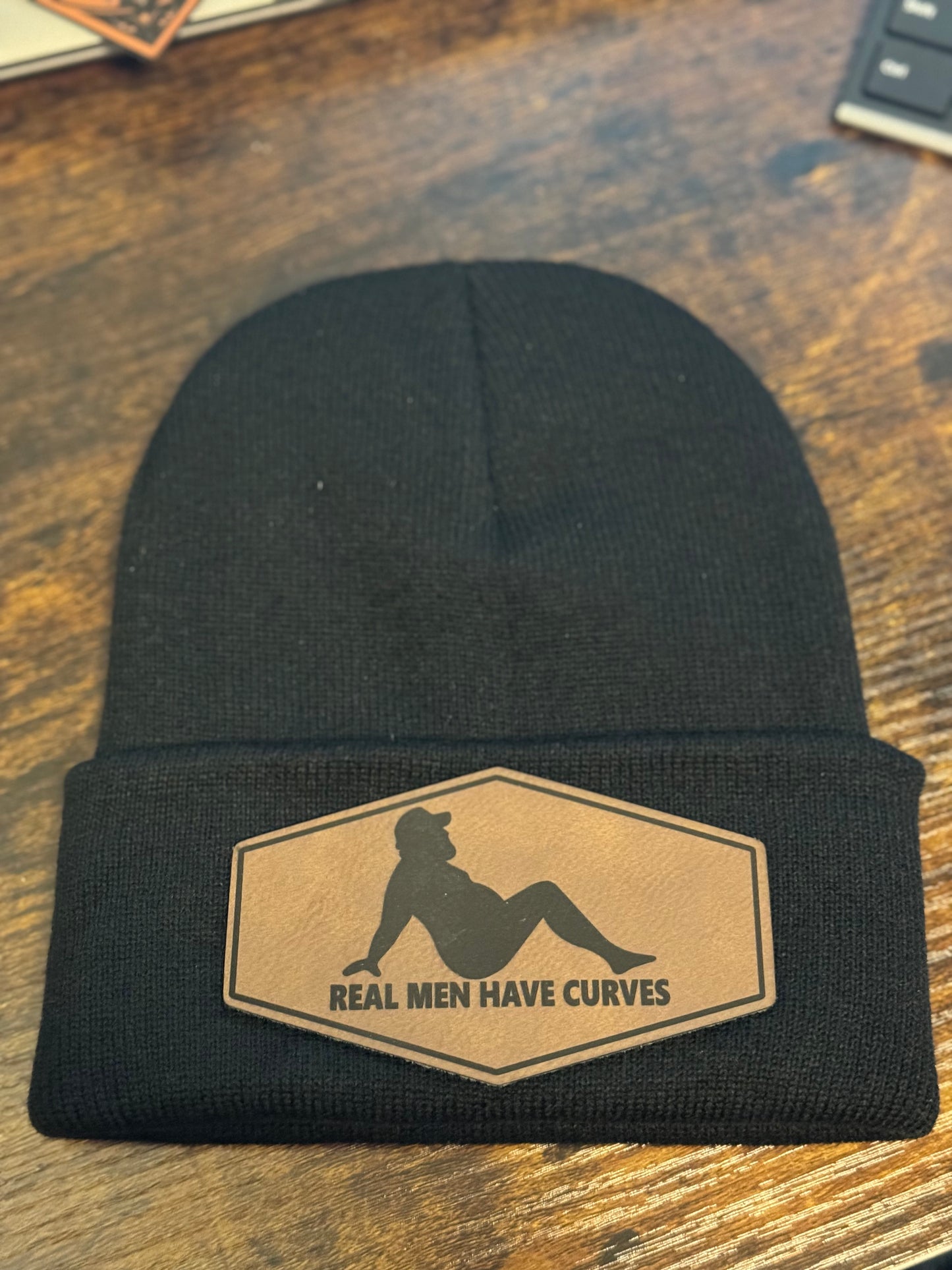 Real Men Have Curves Leather patch on a black beanie